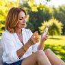 Frau im Garten mit Sonnenschutzmittel fürs Gesicht